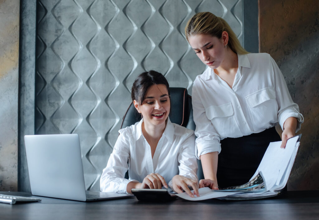 Professional CPA firm & professional CPA services in Alpharetta-young business lady female director sitting at office desk working process business meeting working with colleague solving business tasks office collective concept-strategic tax planning services